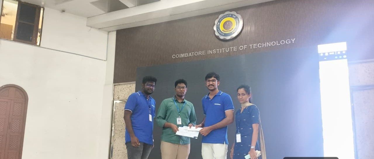 Four students standing on stage at Coimbatore Institute of Technology holding the Coding Relay award certificate.