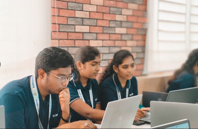 Three students working on laptops during the ZeroDay hackathon finals.